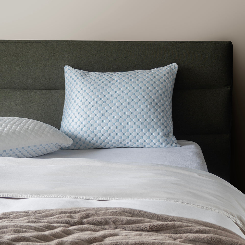CloudComfort hoofdkussen rechtop tegen het hoofdbord van een opgemaakt bed