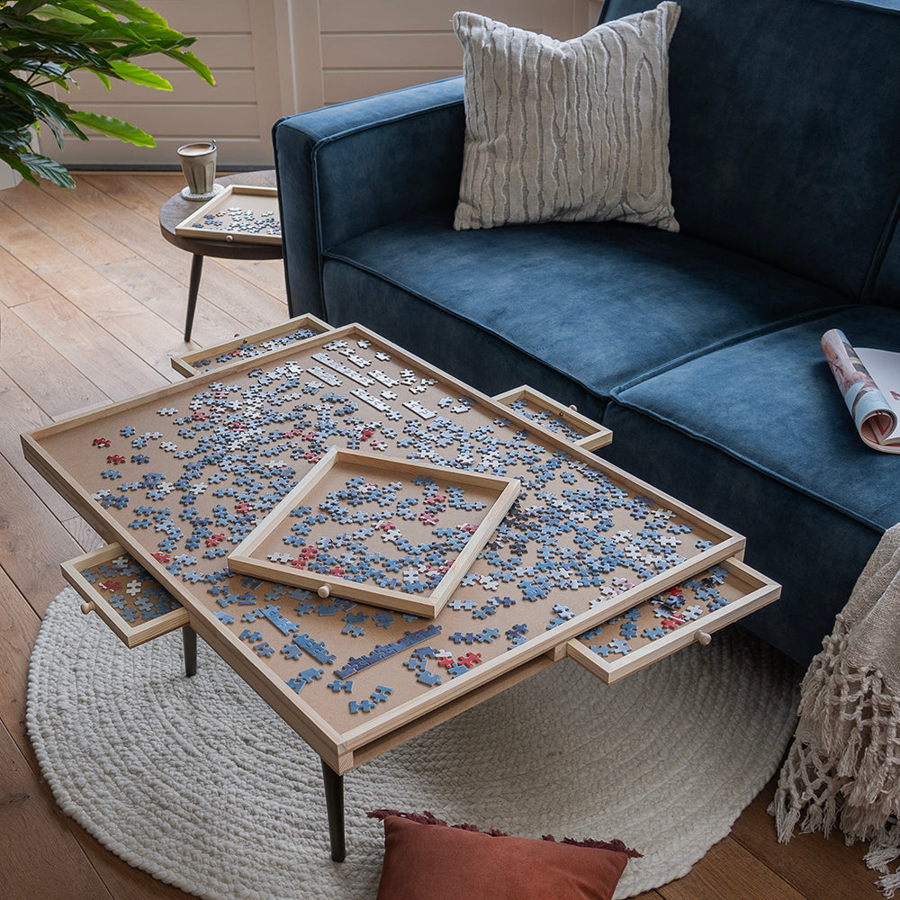 Puzzelplaat op de salontafel met een uitgenomen lade boven op de puzzel