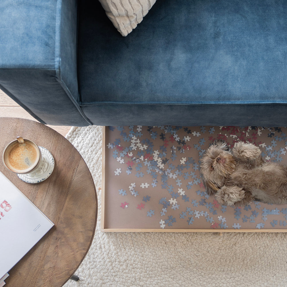 Grote puzzelplaat met beschermhoes deels onder de bank geschoven