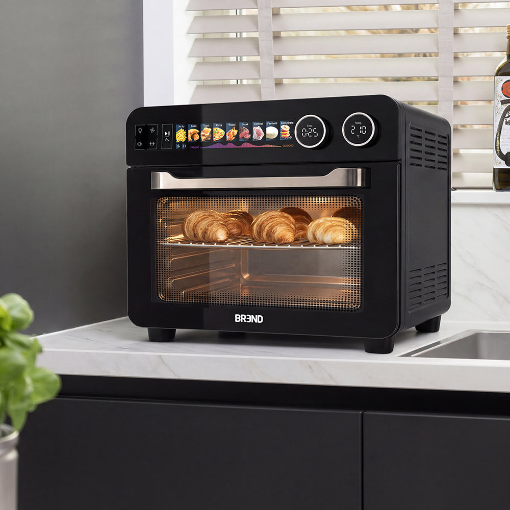 Combi Airfryer Oven op het aanrecht waarin croissants op het rooster worden gebakken