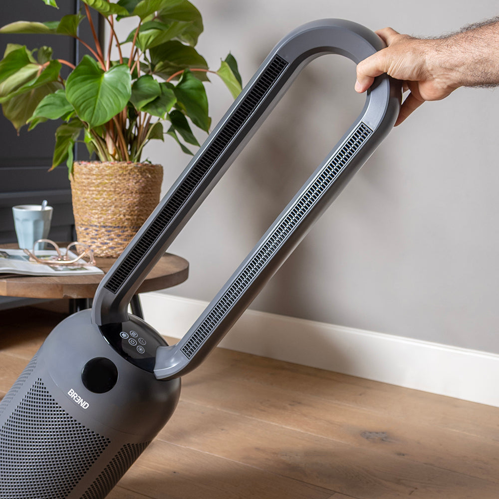Hand kantelt de blaasring van de bladloze ventilatorkachel naar achteren