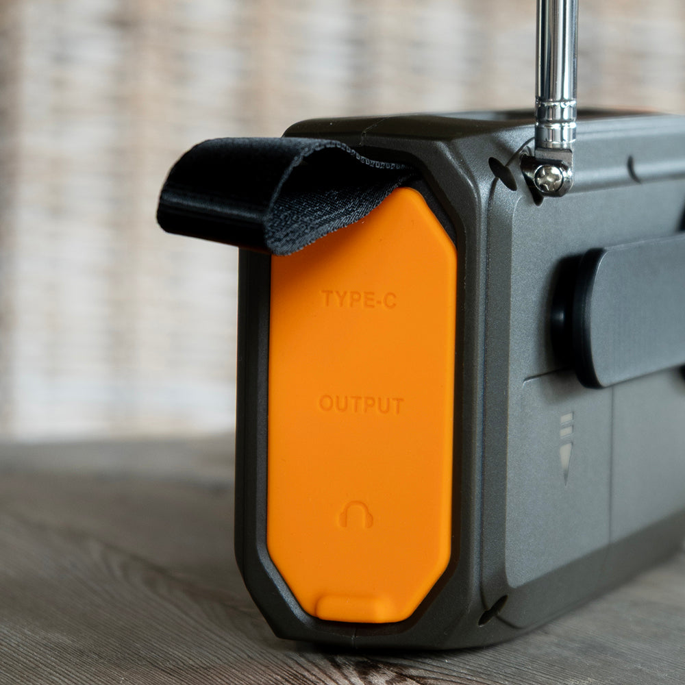Close-up van het oranje klepje over de USB-C-aansluiting aan de zijkant van de noodradio