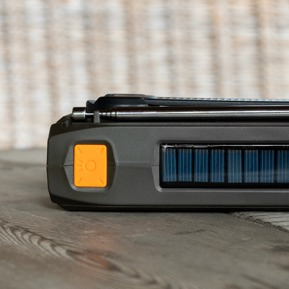 Bovenkant van de noodradio met zonnepaneel en oranje SOS-knop
