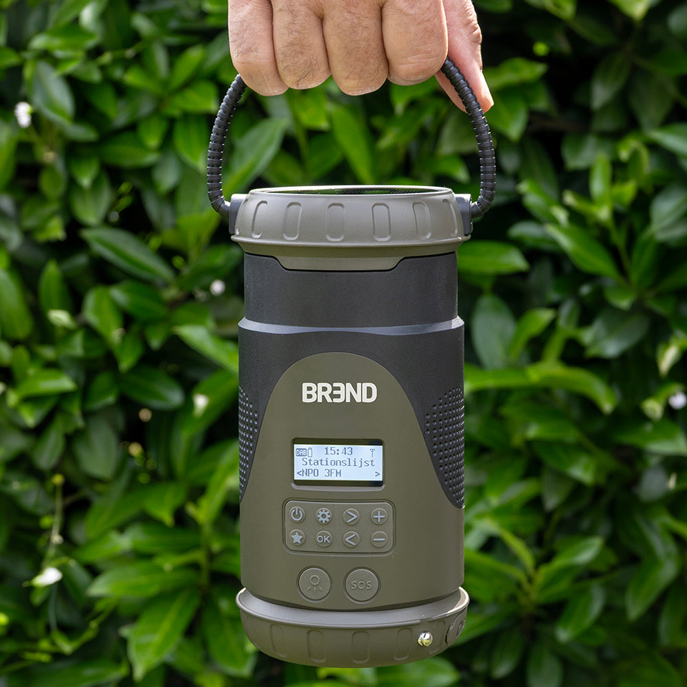 Hand draagt de noodradio met lantaarn aan het draagkoord