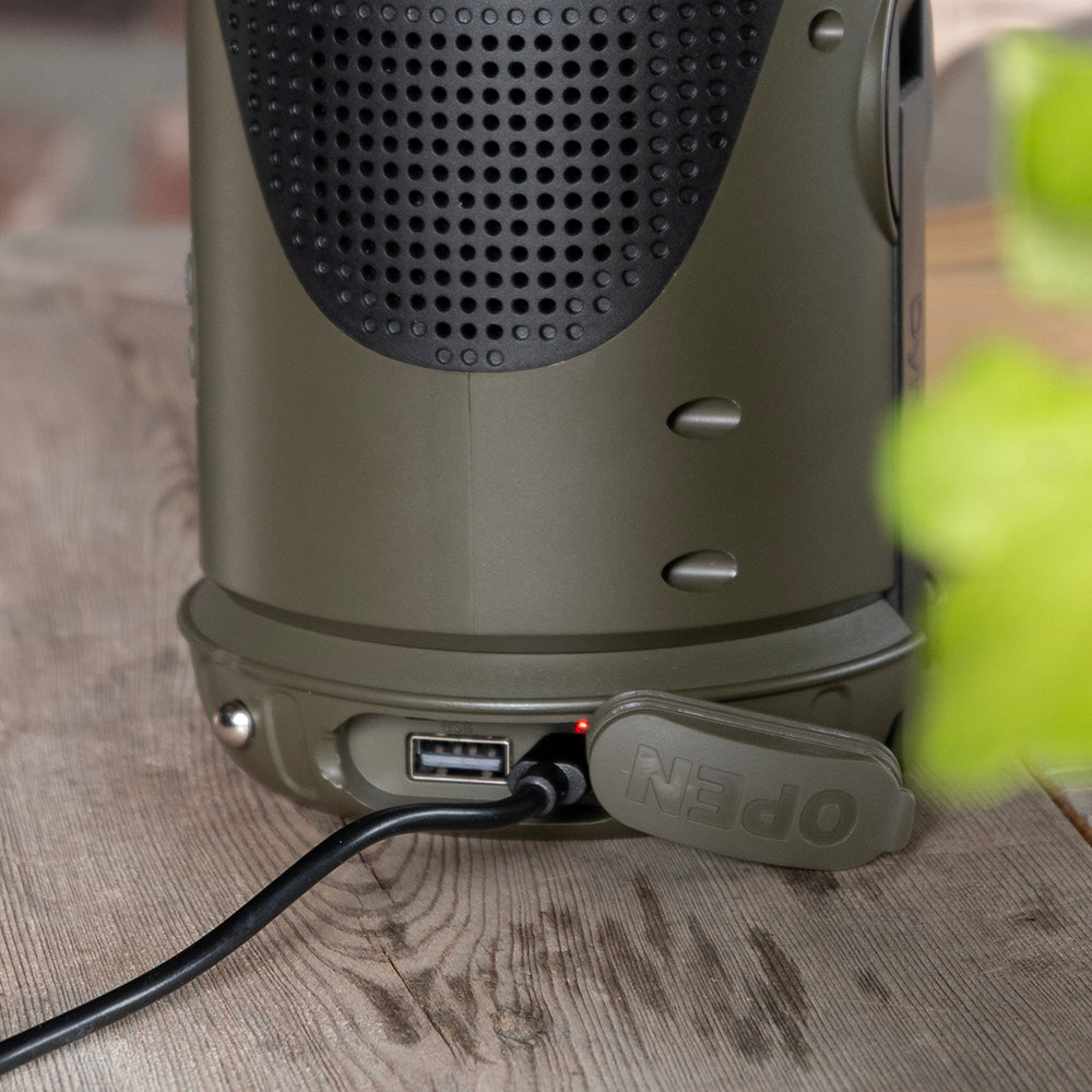 Close-up van de USB-poort onder het klepje van de noodradio met een aangesloten kabel