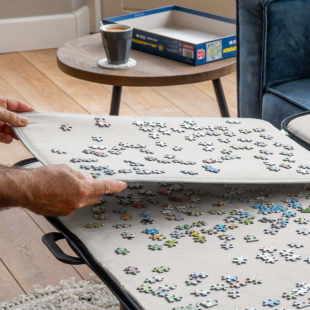 Hand tilt een sorteerblad met puzzelstukjes uit de puzzelmap
