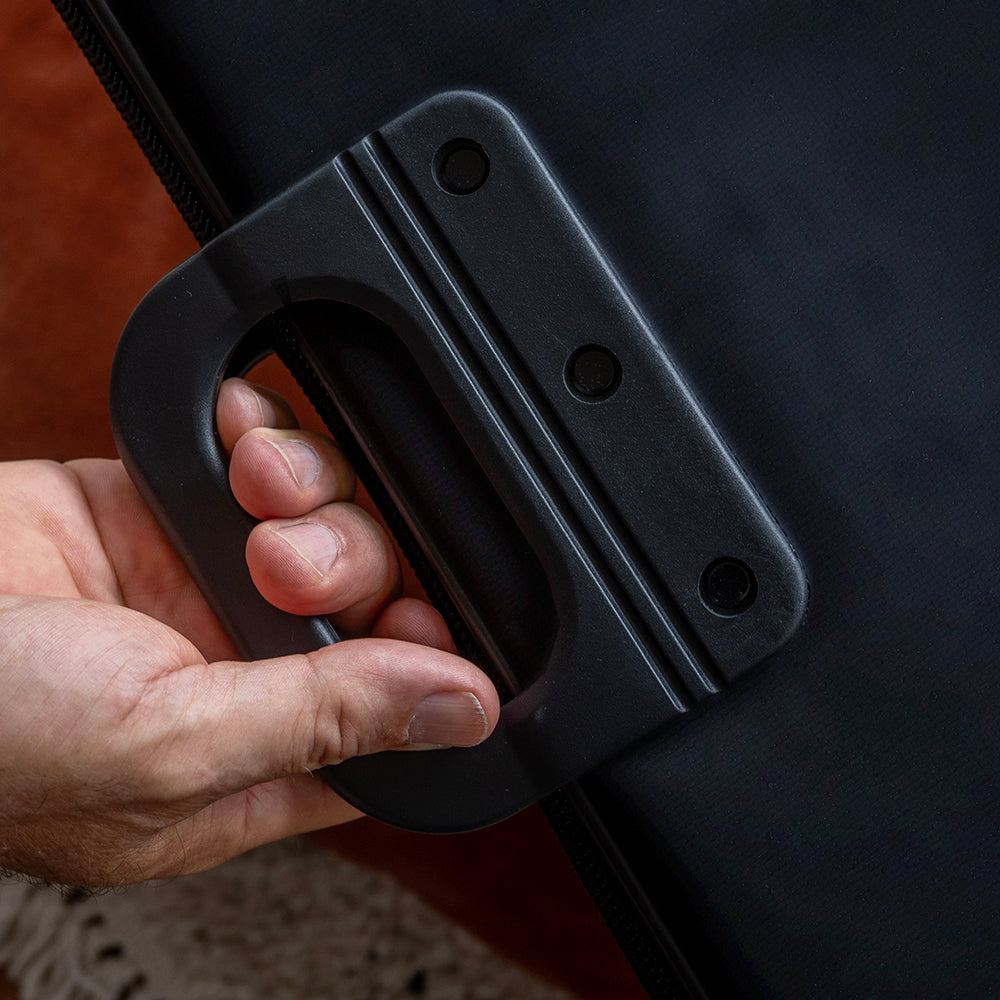 Hand pakt het stevige handvat van de puzzelmap vast