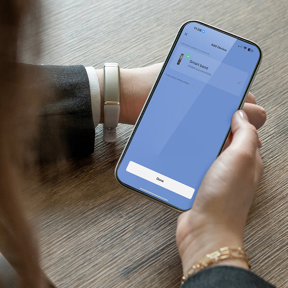 Activity tracker om de pols terwijl de bijbehorende app op een smartphone wordt bekeken