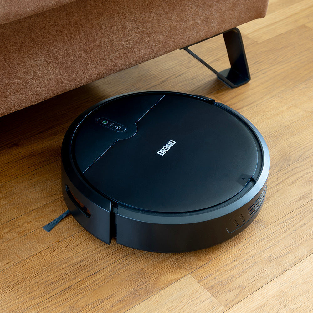 Robotstofzuiger met zijborstels rijdt onder een bank op pootjes door