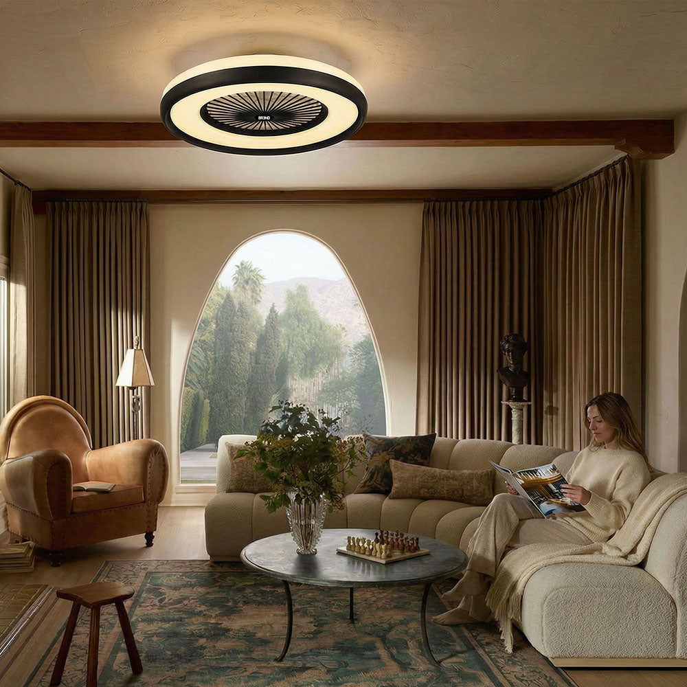 Plafondlamp met ventilator geeft warm wit licht in een woonkamer waar een vrouw op de bank leest