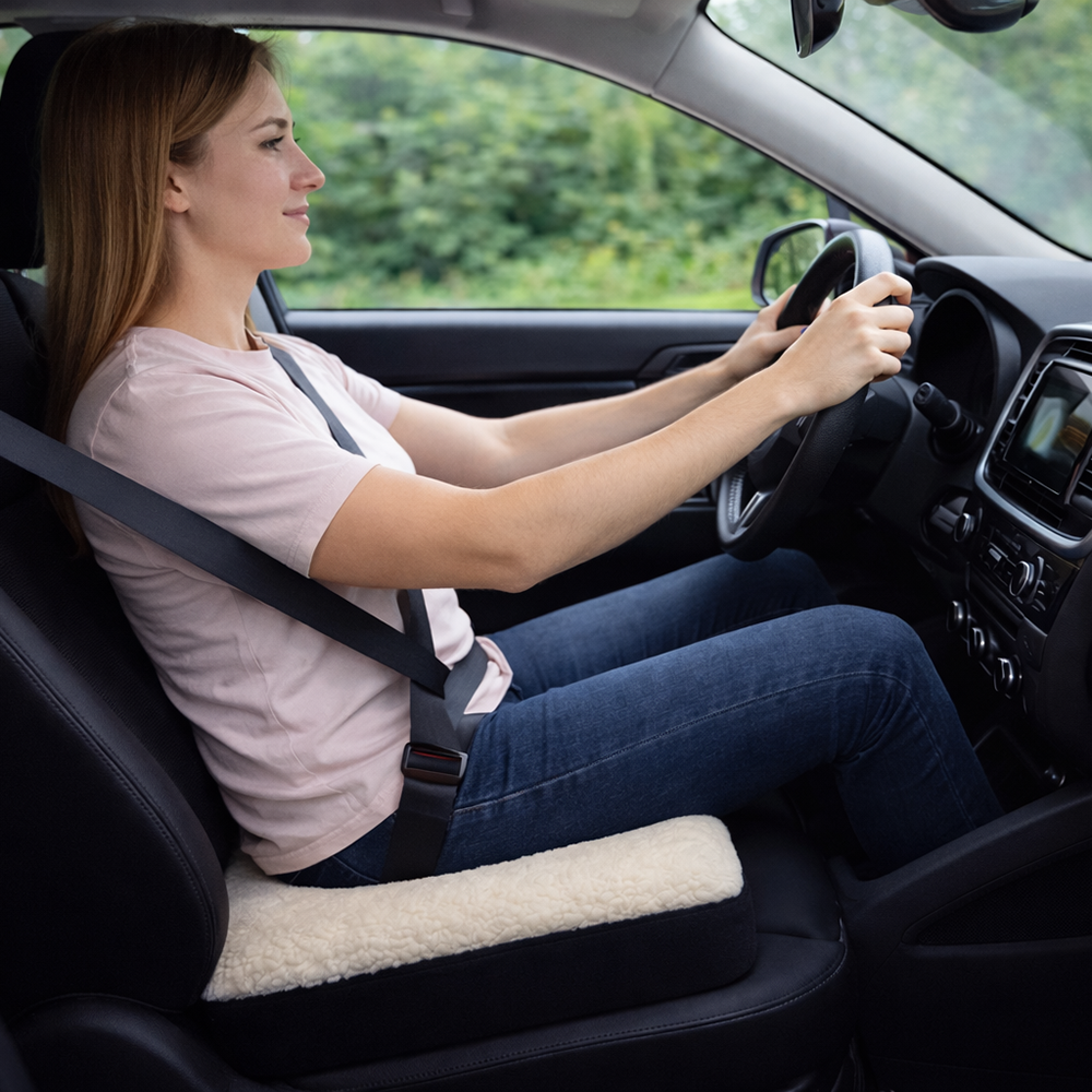 Vrouw rijdt auto met het zitkussen op de bestuurdersstoel